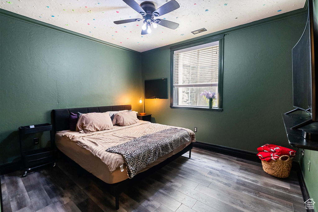 Bedroom featuring wood finished floors, ceiling fan, ornamental molding, and baseboards