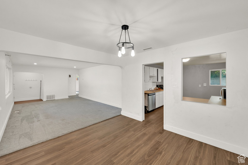 Unfurnished living room featuring wood finished floors, baseboards, and a sink