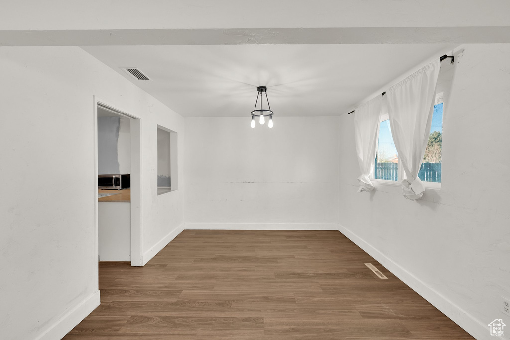 Unfurnished dining area with baseboards and wood finished floors