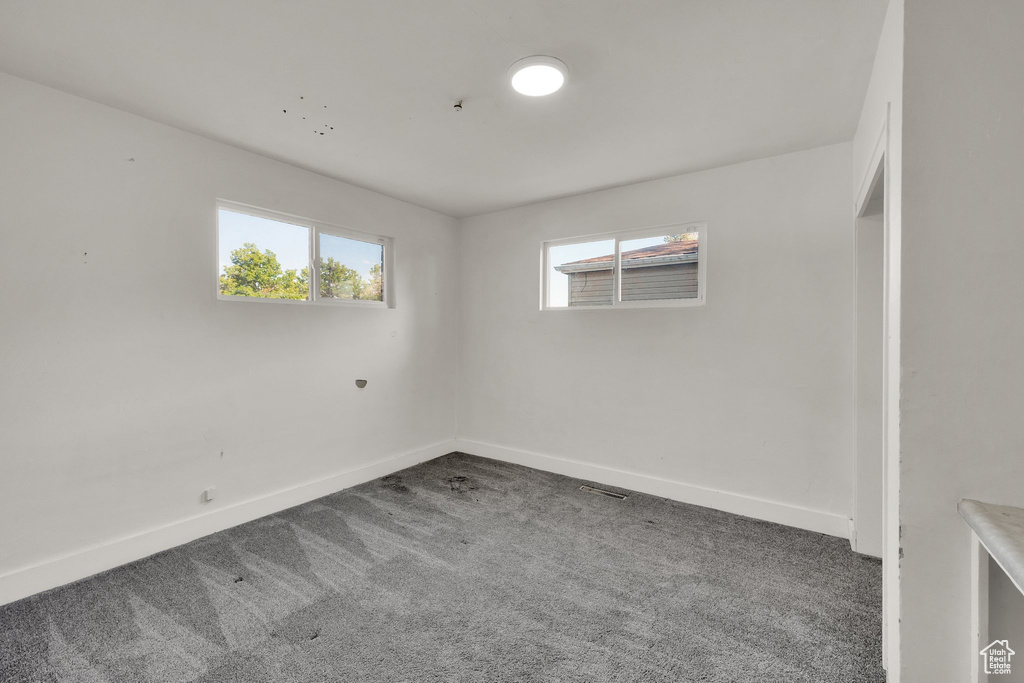 Spare room featuring carpet, healthy amount of natural light, and baseboards