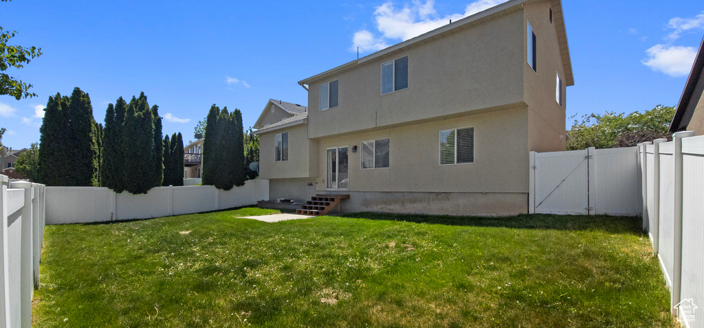 Back of house featuring a gate, stucco siding, and entry steps