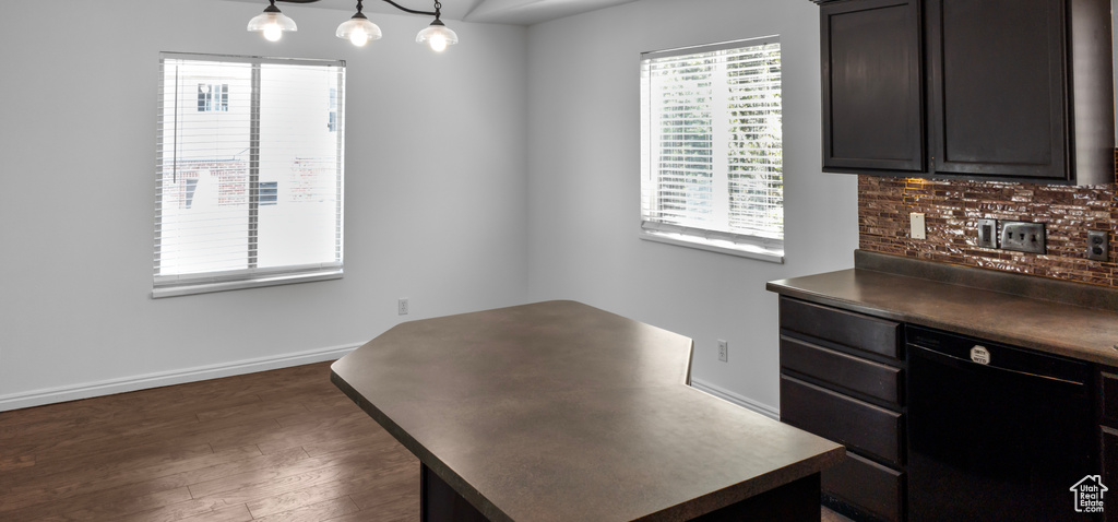 Unfurnished dining area featuring dark wood-style floors and baseboards