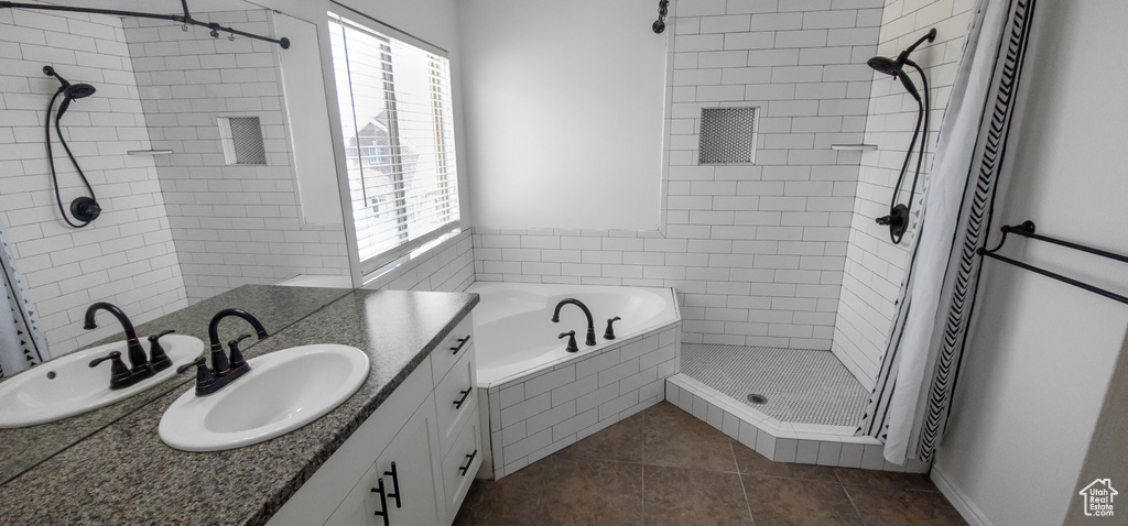 Bathroom with a stall shower, tile patterned flooring, vanity, and a relaxing tiled tub