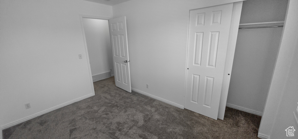 Unfurnished bedroom with carpet flooring, a closet, and baseboards