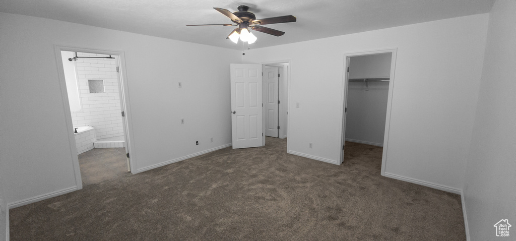 Unfurnished bedroom with carpet floors, a walk in closet, ensuite bathroom, a closet, and baseboards