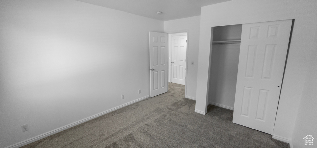 Unfurnished bedroom with carpet, baseboards, and a closet