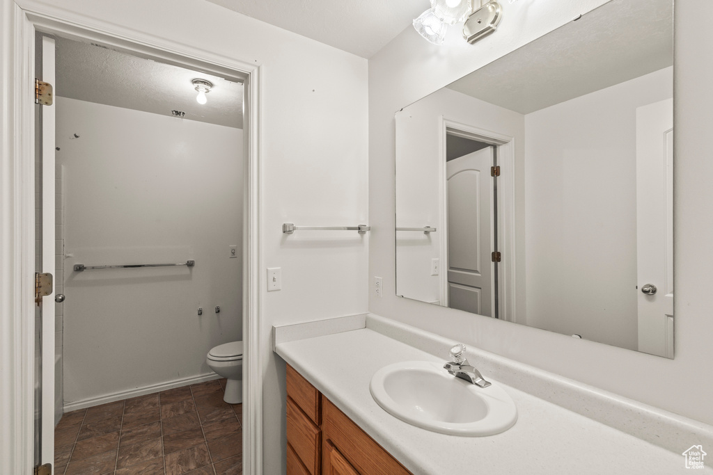 Bathroom with vanity, toilet, and baseboards