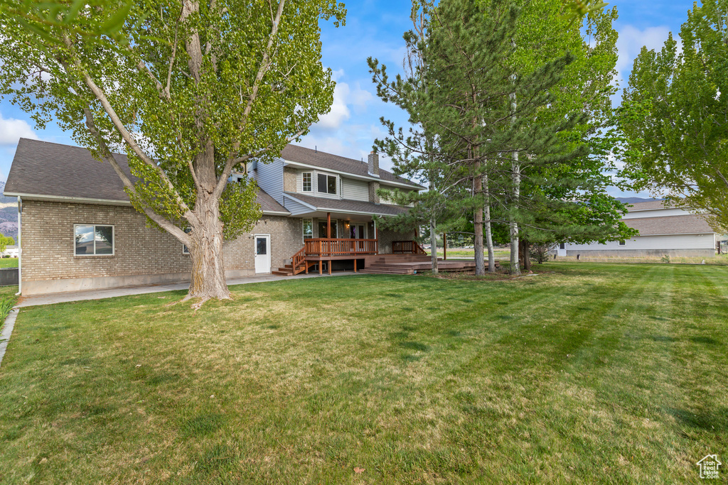 View of green lawn with a wooden deck