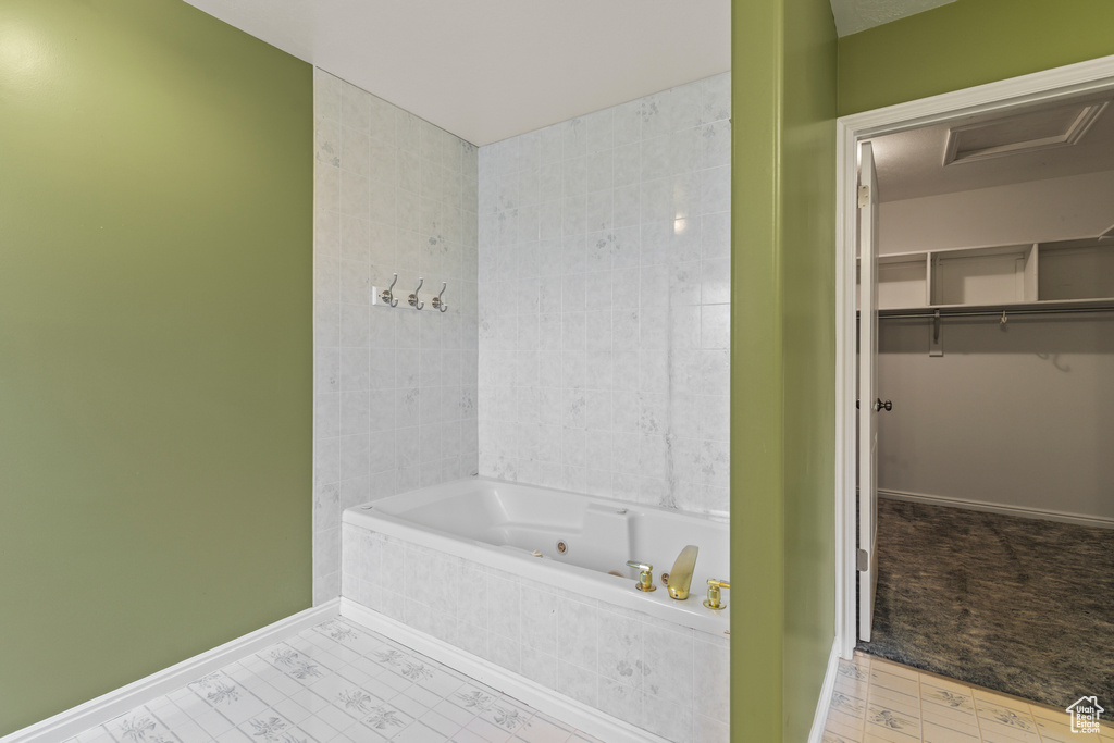 Bathroom featuring a jetted tub and baseboards
