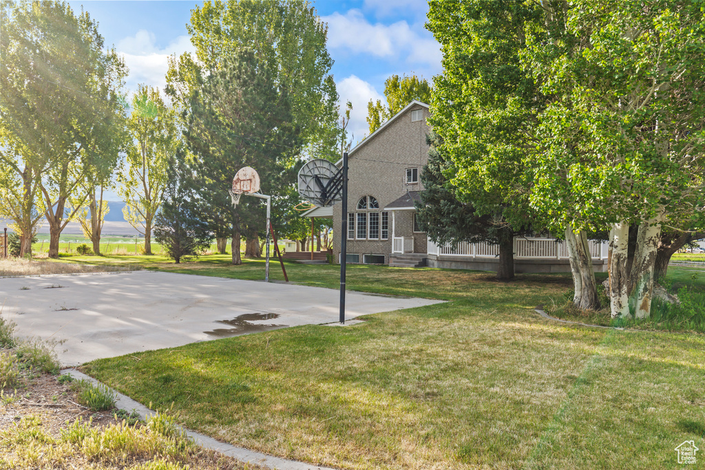 View of basketball court with a lawn and basketball court