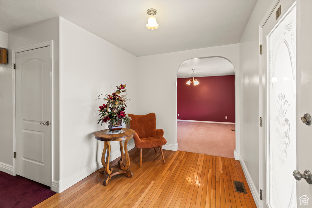 Living area with arched walkways, light wood finished floors, and baseboards