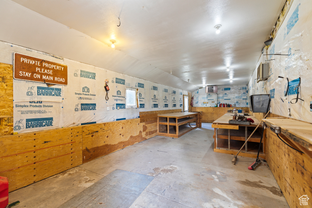 Miscellaneous room with a workshop area and unfinished concrete flooring