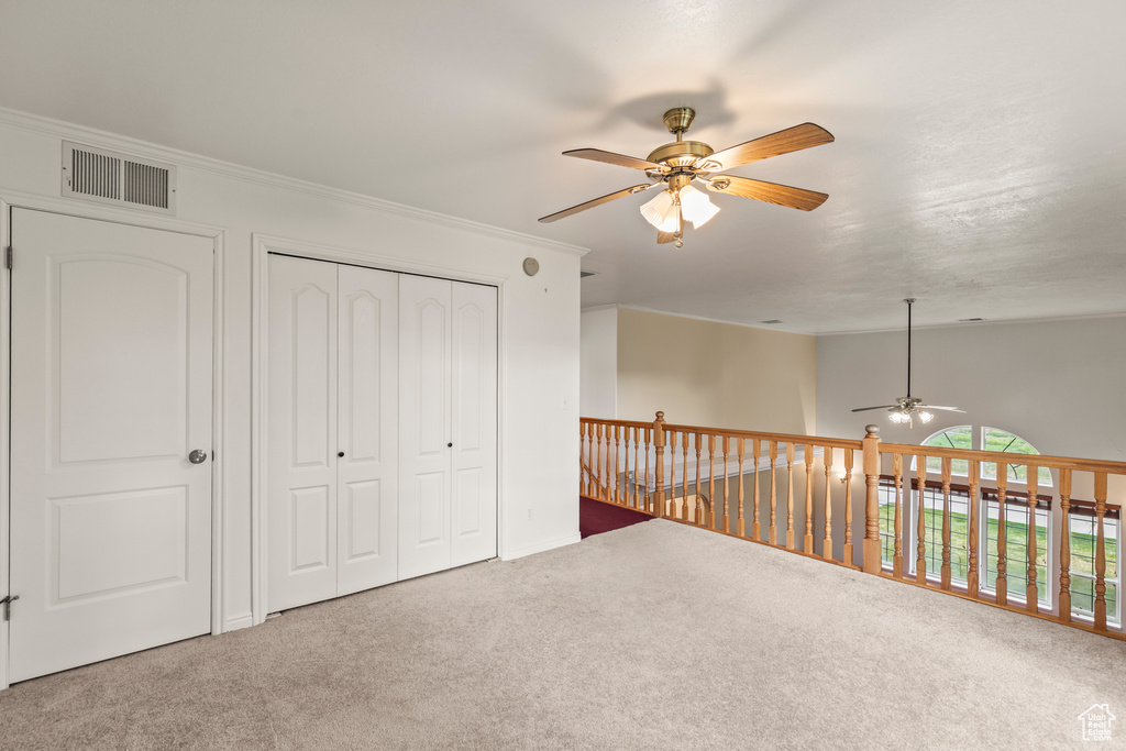 Unfurnished bedroom with carpet floors, ornamental molding, and a closet