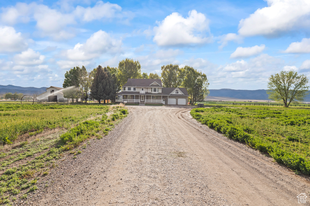 View of dirt / gravel driveway featuring a view of countryside and a mountain view