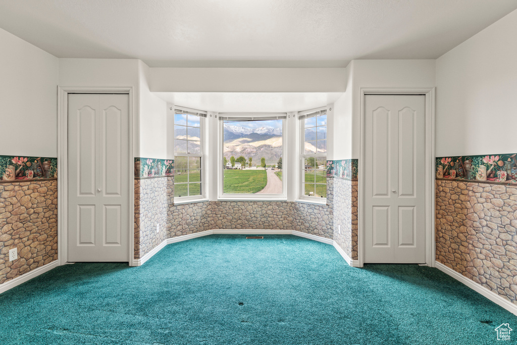Carpeted empty room with a wainscoted wall