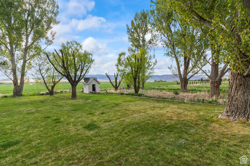 View of green lawn with a view of rural / pastoral area and a mountain view