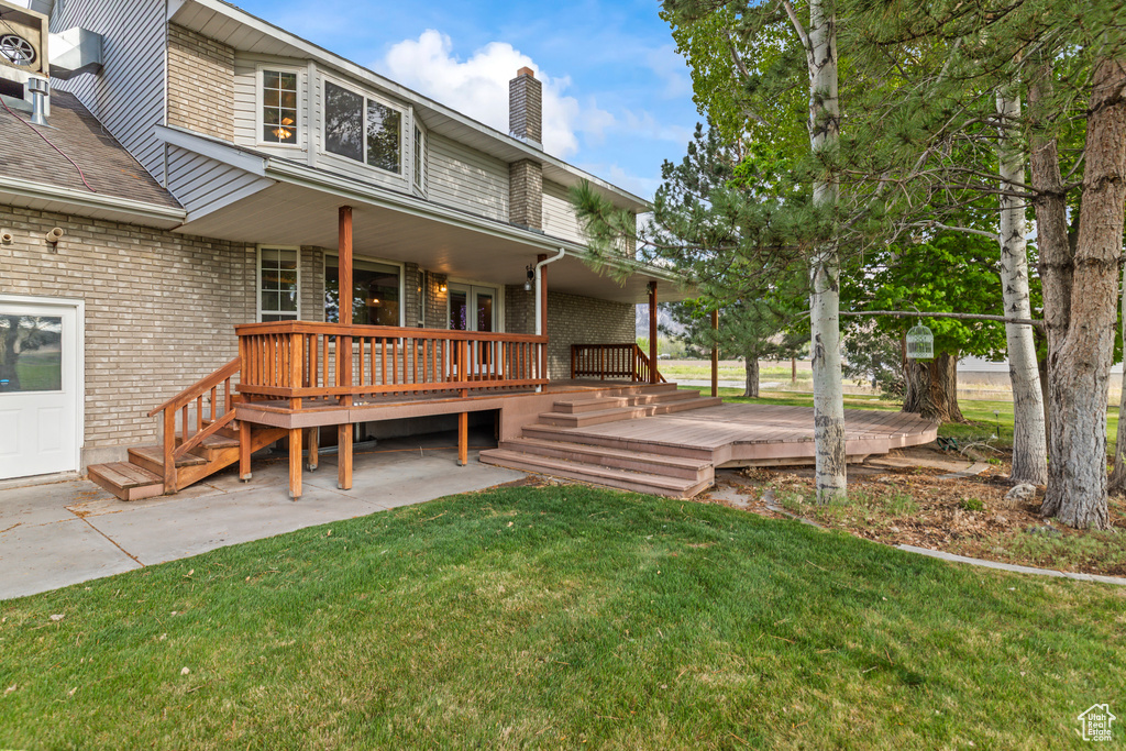 Wooden deck with a lawn and a patio area
