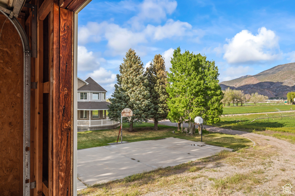 View of basketball court featuring basketball court, a mountain view, and a lawn