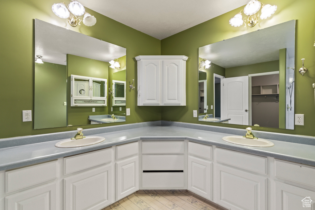 Full bath featuring a chandelier and double vanity