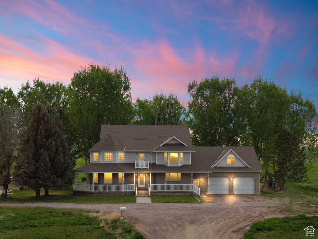 View of front of home with covered porch, driveway, and a garage