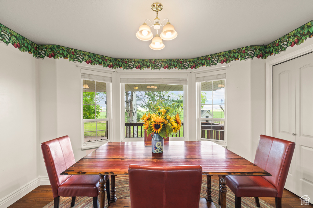 Dining room featuring a chandelier, dark wood-type flooring, and baseboards