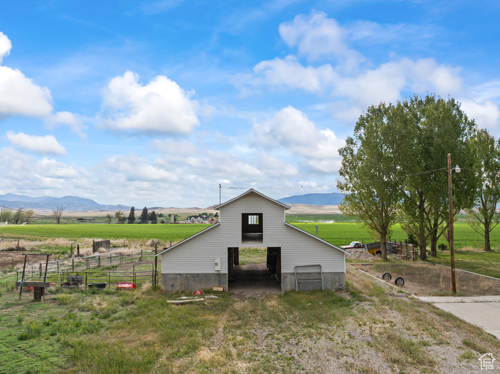 View of barn with a mountain view, fence, and a view of countryside