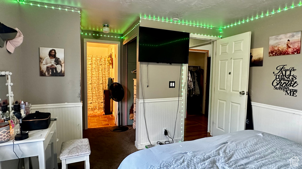 Carpeted bedroom featuring a wainscoted wall