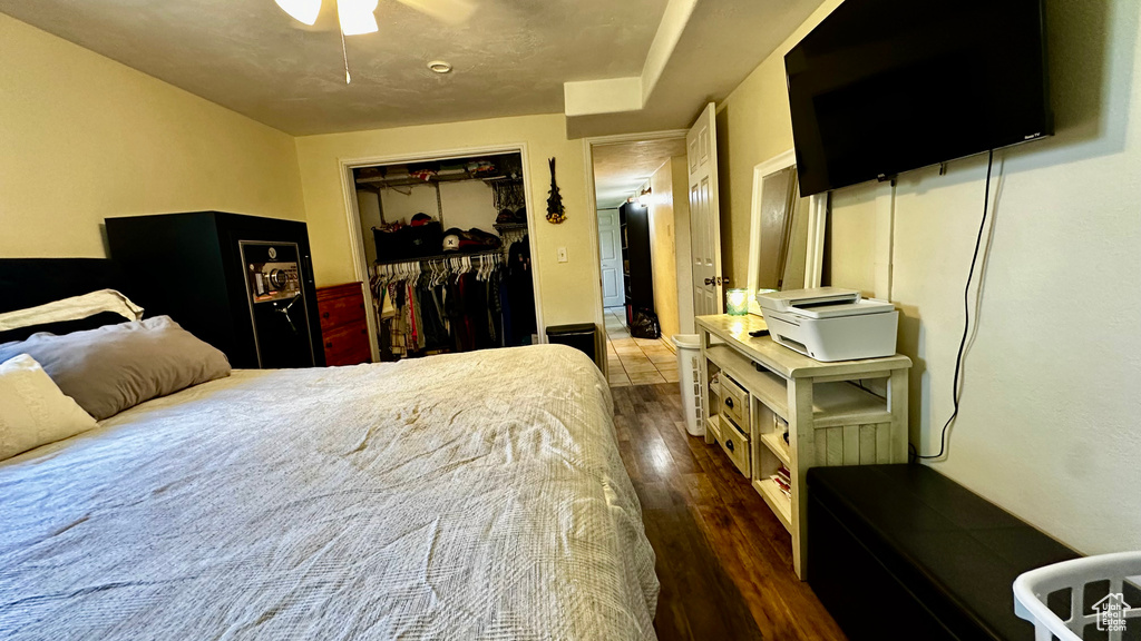 Bedroom with a closet, wood finished floors, and a ceiling fan