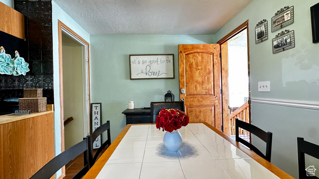 Tiled dining area with a textured ceiling