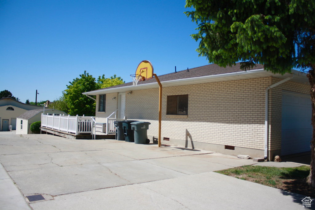 View of side of property with brick siding, crawl space, and a wooden deck