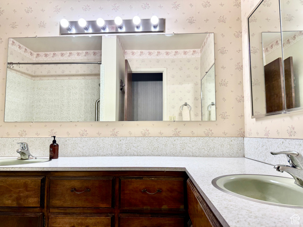 Full bathroom with wallpapered walls and vanity