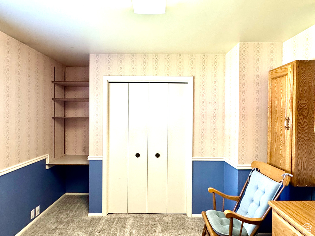 Living area with carpet flooring and wallpapered walls