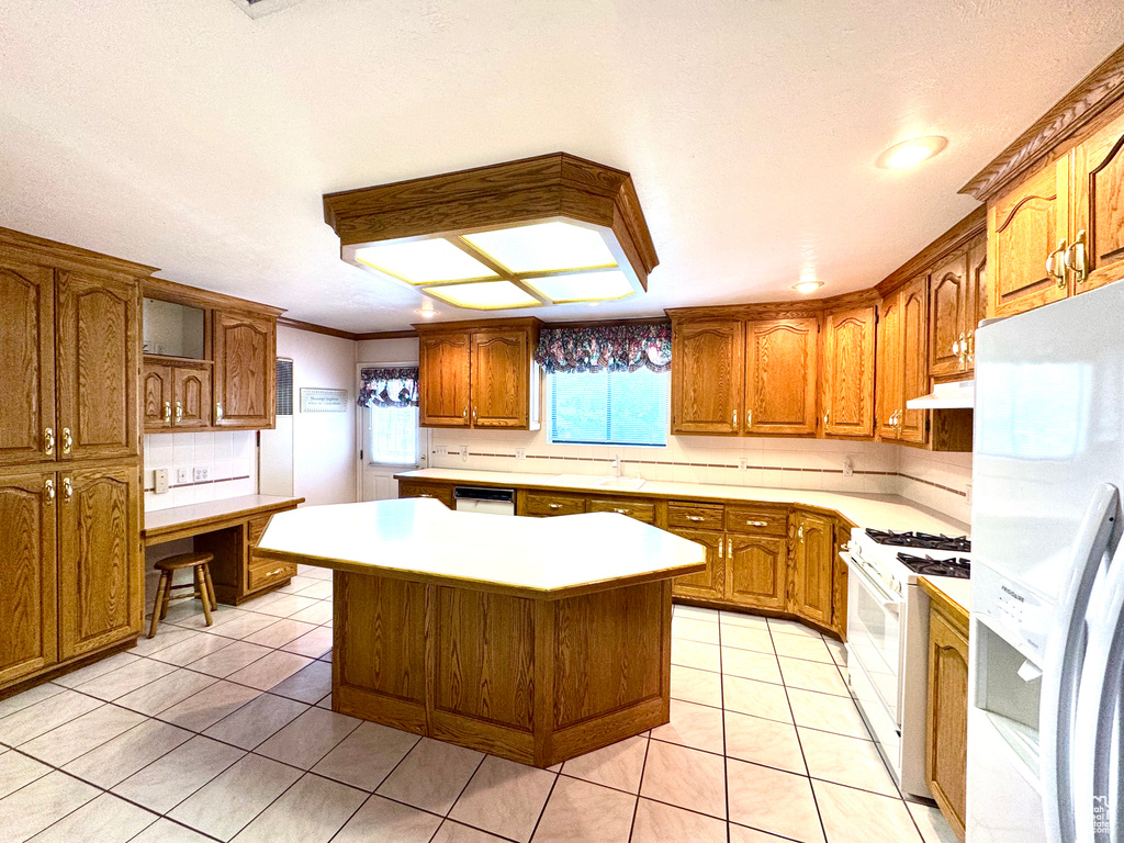 Kitchen featuring white appliances, under cabinet range hood, brown cabinets, open shelves, and a kitchen island