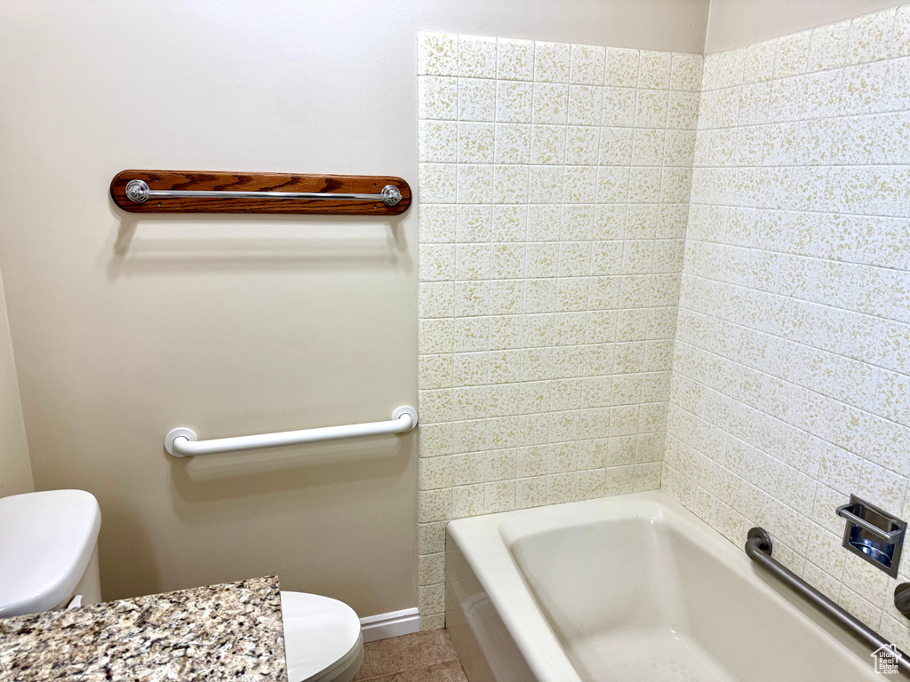 Full bath with toilet, tile patterned floors, and tub / shower combination