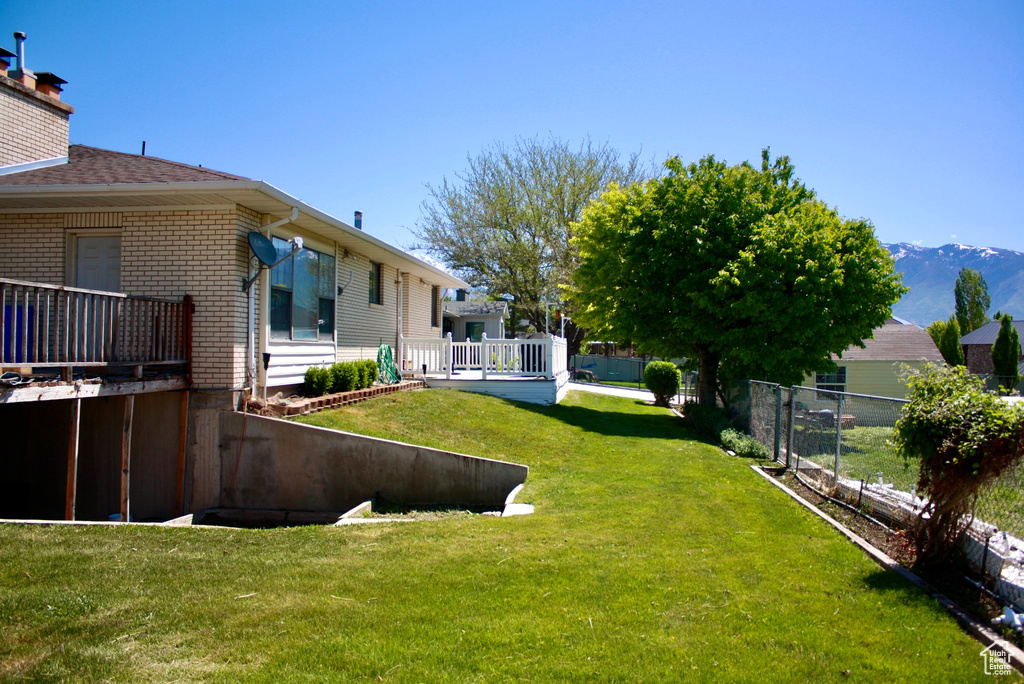 View of yard featuring a deck with mountain view