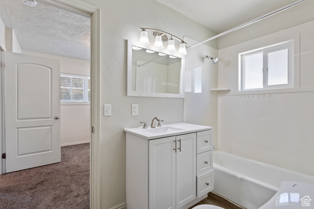 Full bathroom featuring vanity, shower / bath combination, and a textured ceiling