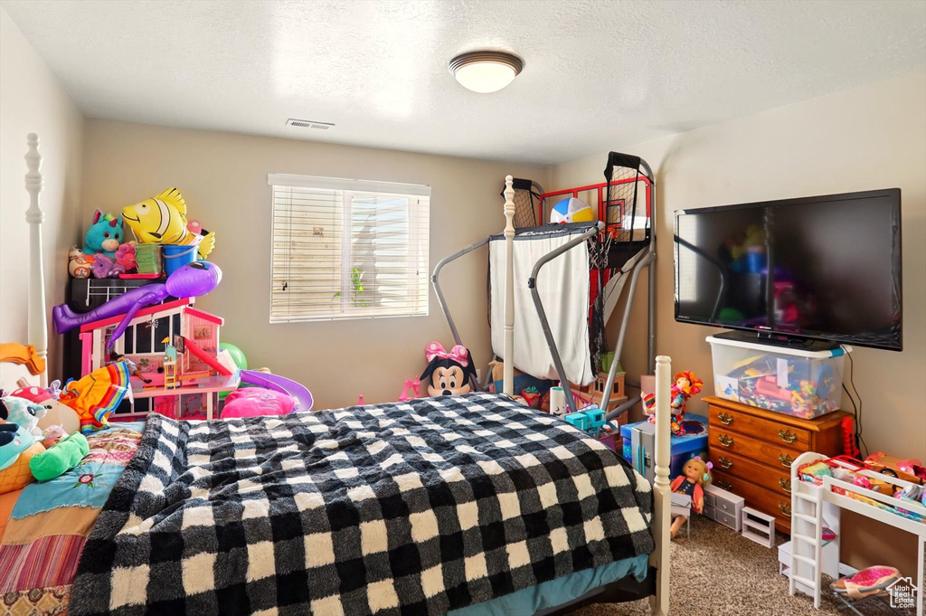 Bedroom featuring carpet floors and a textured ceiling