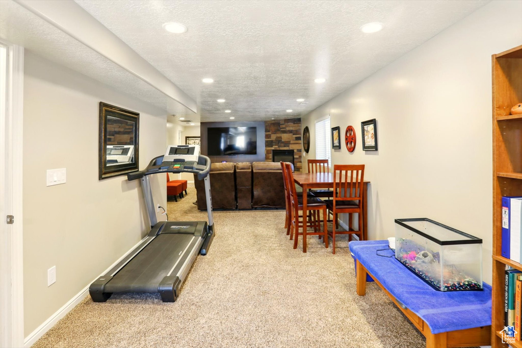 Exercise area featuring carpet flooring, a fireplace, recessed lighting, and baseboards