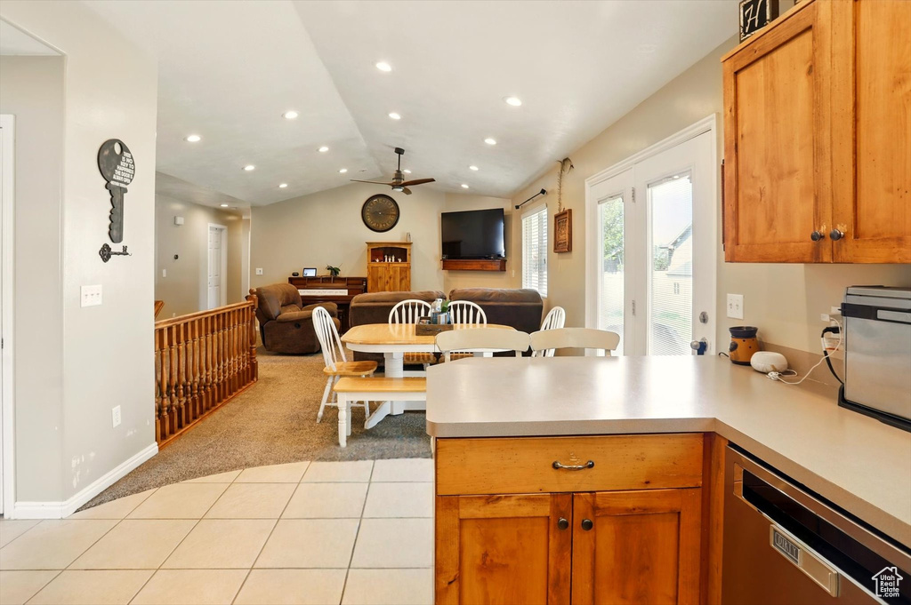 Kitchen featuring stainless steel dishwasher, open floor plan, ceiling fan, vaulted ceiling, and light countertops