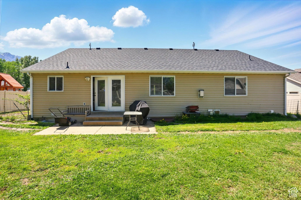 Back of property with a patio, a shingled roof, and a mountain view
