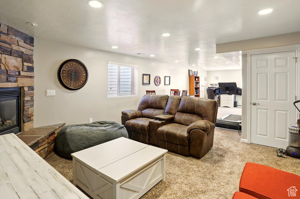 Living area with light carpet, a fireplace, and recessed lighting