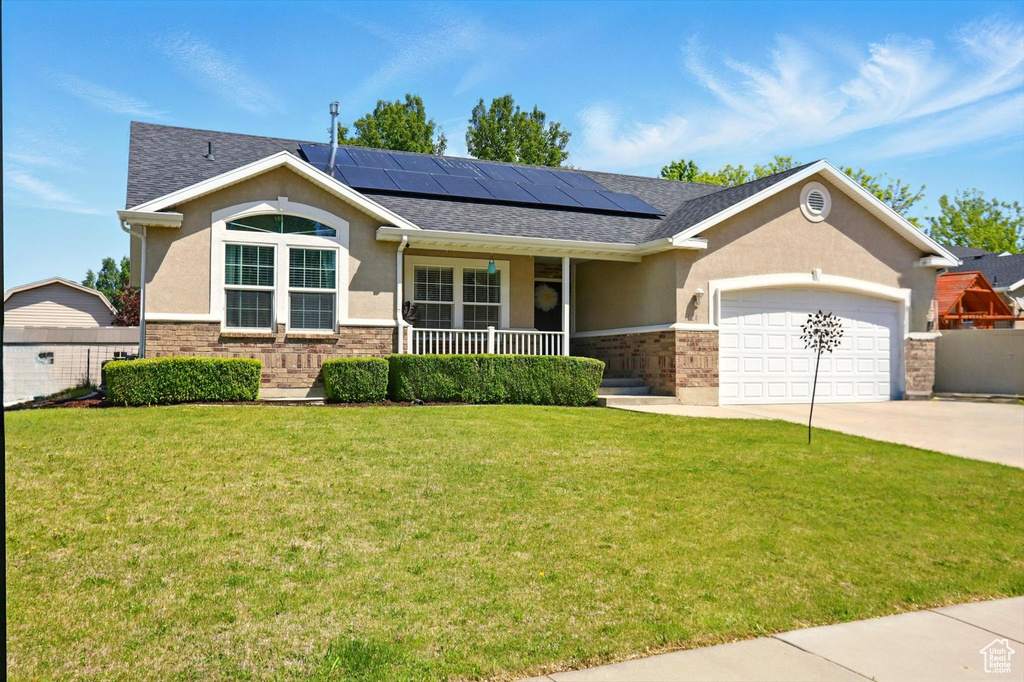Single story home featuring stucco siding, a porch, an attached garage, and a front lawn