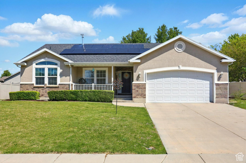 Ranch-style house with covered porch, a front lawn, an attached garage, stucco siding, and driveway