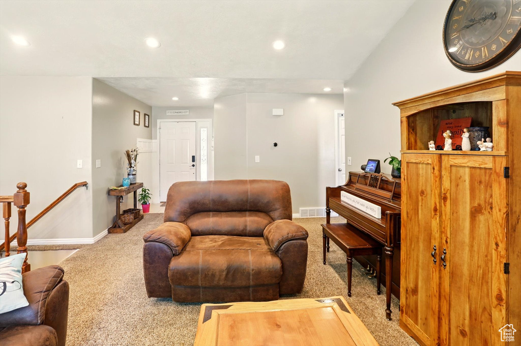 Carpeted living area with recessed lighting and baseboards