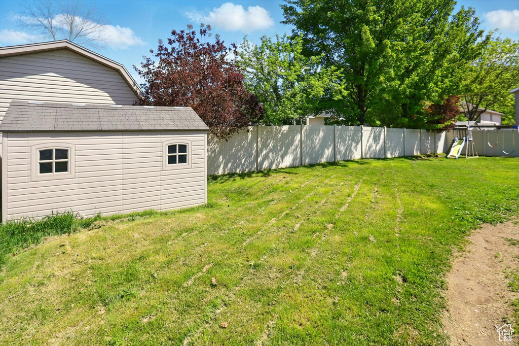 View of yard featuring an outdoor structure, a shed, and a playground
