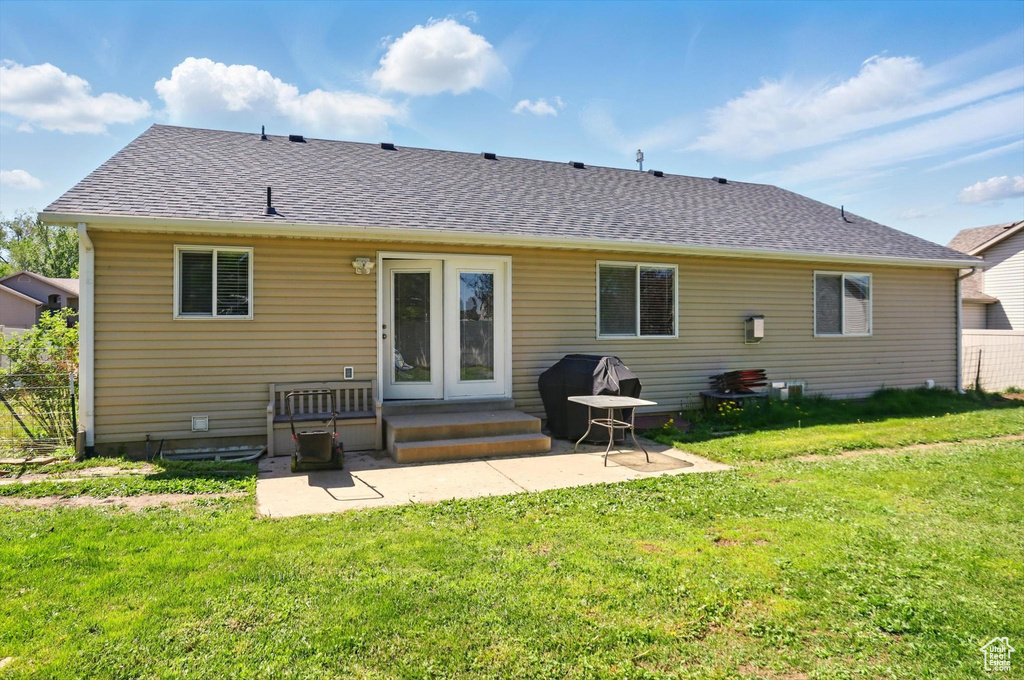 Rear view of property featuring a patio and a shingled roof