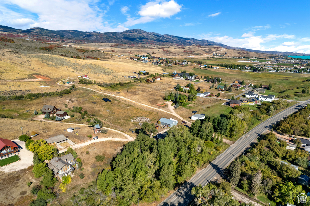 Aerial view of property and surrounding area with a mountainous background and rural landscape