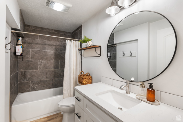 Full bath featuring toilet, vanity, shower / bath combo with shower curtain, and wood finished floors