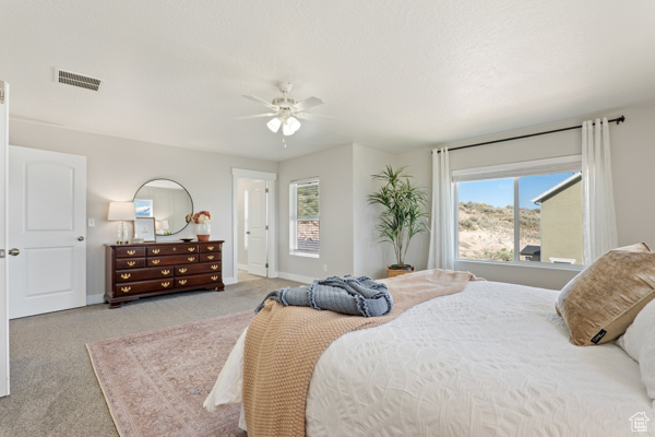 Bedroom with carpet, baseboards, and a ceiling fan