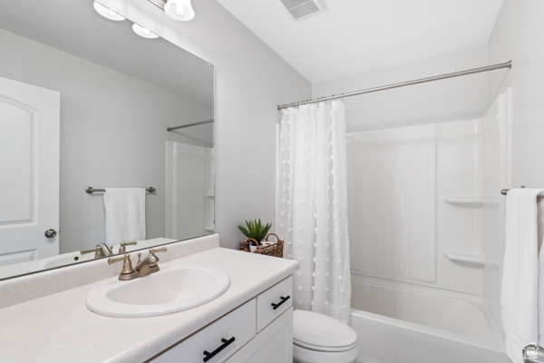 Full bath featuring toilet, vanity, and shower / tub combo
